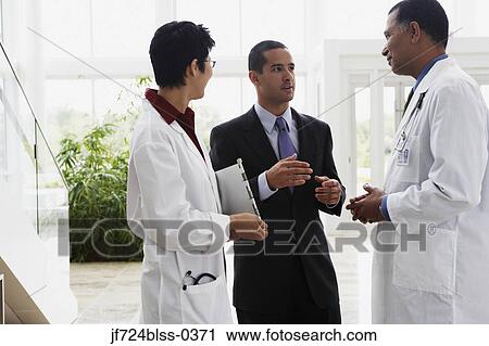 Stock Image - Doctors talking to businessman. Fotosearch