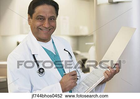 Middle-aged Indian male doctor with chart View Large Photo Image Stock Image - Middle-aged Indian male doctor with chart. Fotosearch