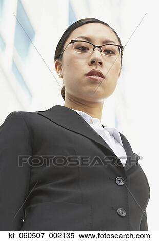 Stock Photography - Low angle view of Asian businesswoman outdoors. Fotosearch