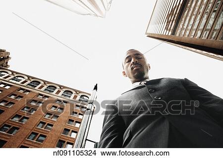Low angle view of businessman in urban setting View Large Photo Image Picture - Low angle view of businessman in urban setting. Fotosearch
