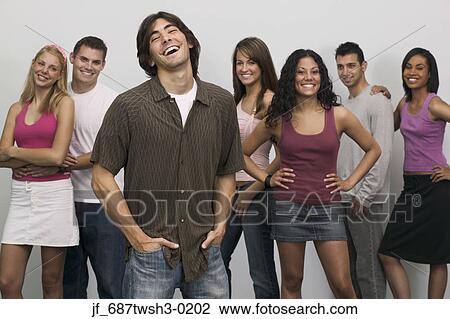 Stock Image - Group of people standing together looking at camera smiling. Fotosearch