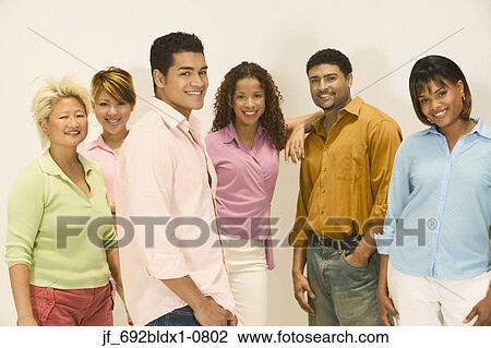 Stock Image - Group of young people standing together looking at camera smiling. Fotosearch