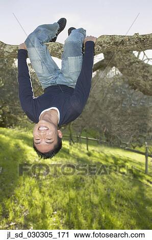 Stock Photography of Portrait of a young man hanging from a tree jl_sd ...