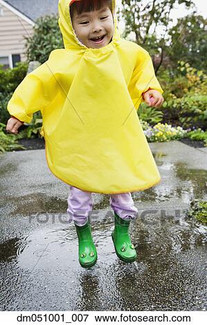 Young boy jumping in rain with rubber boots and raincoat on View Large Photo Image Stock Photo - Young boy jumping in rain with rubber boots and raincoat on. Fotosearch