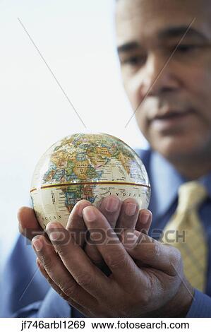 Stock Photo - African American businessman holding globe. Fotosearch