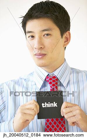 Picture - Portrait of a businessman holding a card with the word think. Fotosearch