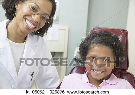 African female dentist examining young female patient View Large Photo Image Stock Photograph - African female dentist examining young female patient. Fotosearch