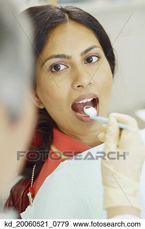 Dentist holding dental mirror in female patient's mouth View Large Photo Image Stock Photo - Dentist holding dental mirror in female patient's mouth. Fotosearch