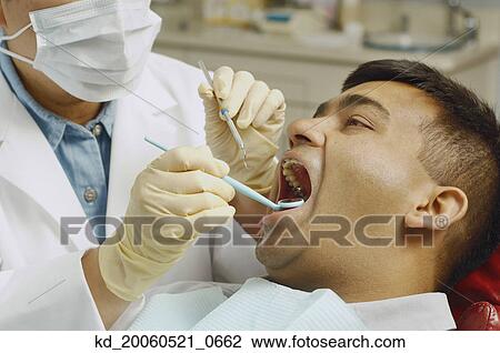 Dentist working on Indian man View Large Photo Image Stock Image - Dentist working on Indian man. Fotosearch