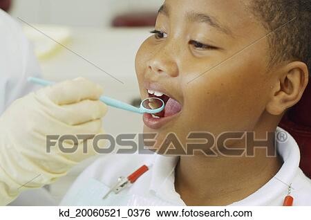 Dentist's hand holding dental mirror in boy's mouth View Large Photo Image Stock Photograph - Dentist's hand holding dental mirror in boy's mouth. Fotosearch