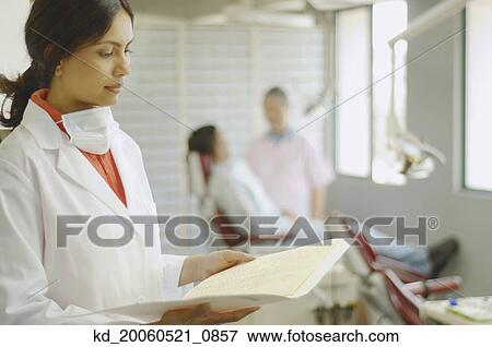Indian female dentist looking at chart View Large Photo Image Stock Photo - Indian female dentist looking at chart. Fotosearch