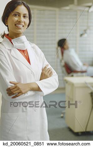Indian female dentist smiling with patient in background View Large Photo Image Stock Image - Indian female dentist smiling with patient in background. Fotosearch