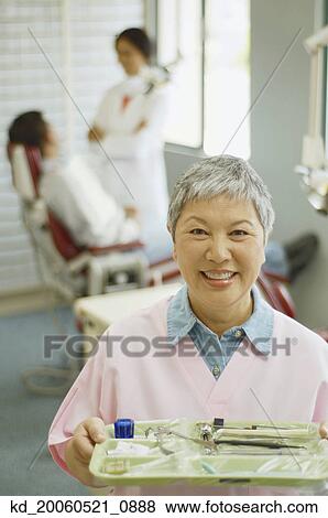 Senior Asian female dental assistant smiling View Large Photo Image Stock Photo - Senior Asian female dental assistant smiling. Fotosearch