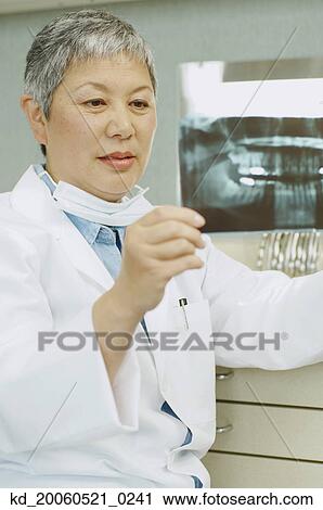Senior Asian female dentist looking at x-rays View Large Photo Image Stock Image - Senior Asian female dentist looking at x-rays. Fotosearch