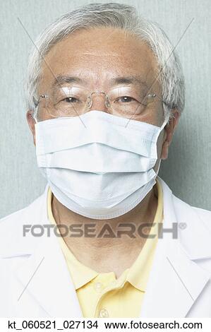 Senior Asian male dentist wearing surgical mask View Large Photo Image Picture - Senior Asian male dentist wearing surgical mask. Fotosearch