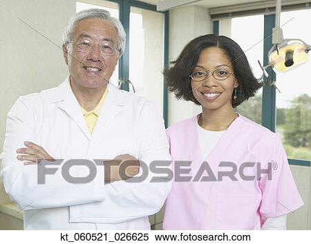 Senior Asian male dentist with African female dental assistant View Large Photo Image Stock Photography - Senior Asian male dentist with African female dental assistant. Fotosearch