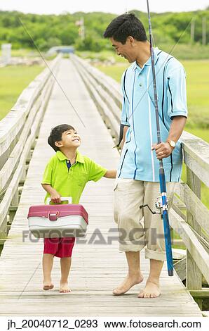 Father and son walking on a pier holding fishing gear View Large Photo Image Stock Image - Father and son walking on a pier holding fishing gear. Fotosearch