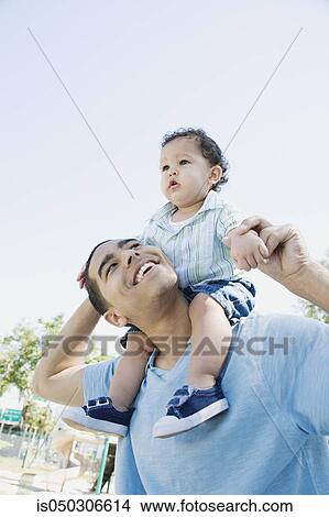 Picture - Young African father with baby on shoulders. Fotosearch