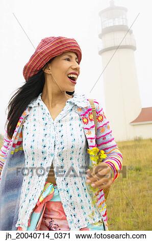 Stock Image - Young woman smiling looking sideways. Fotosearch