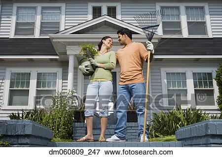 Hispanic couple smiling at each other in front of house View Large Photo Image Stock Photo - Hispanic couple smiling at each other in front of house. Fotosearch
