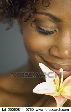 Close up of African woman smelling flower View Large Photo Image Stock Image - Close up of African woman smelling flower. Fotosearch
