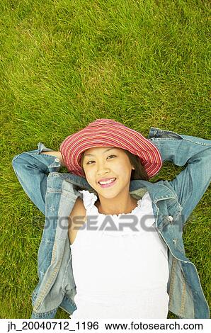 High angle view of a teenage girl lying on a lawn View Large Photo Image Stock Photograph - High angle view of a teenage girl lying on a lawn. Fotosearch