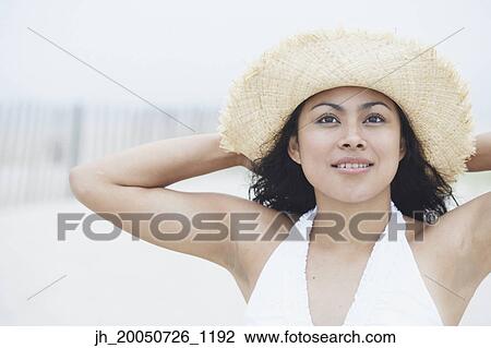Young woman wearing a straw hat View Large Photo Image Stock Image - Young woman wearing a straw hat. Fotosearch