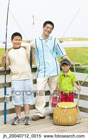 Stock Photography - Father and his two sons standing at a pier with fishing gear. Fotosearch