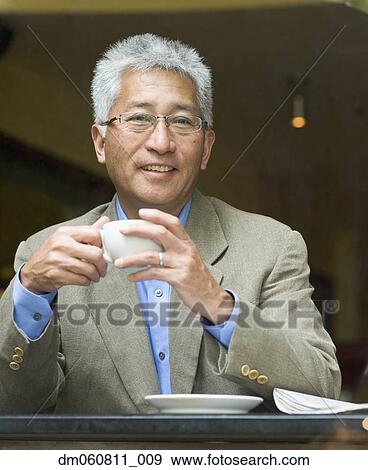 Senior Asian man holding cup of coffee View Large Photo Image Stock Photo - Senior Asian man holding cup of coffee. Fotosearch