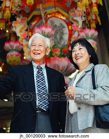 Stock Image - Senior couple standing together smiling. Fotosearch
