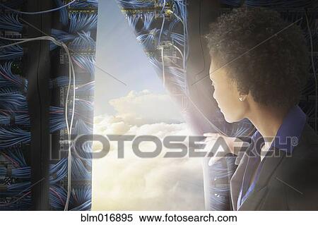 Stock Photography - African American businesswoman pulling back curtain to clouds. Fotosearch