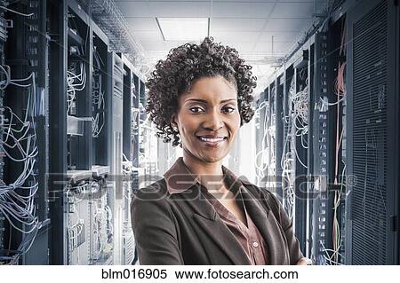 Stock Photography - African American businesswoman smiling in server room. Fotosearch