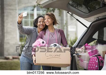 Stock Photograph - African American mother taking picture with daughter. Fotosearch
