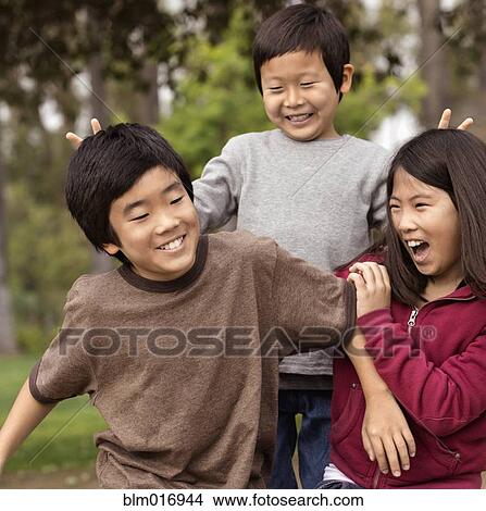 Picture - Asian children playing together outdoors. Fotosearch