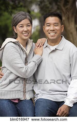 Stock Photo - Asian couple smiling together outdoors. Fotosearch