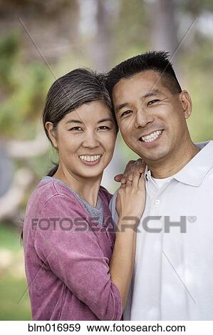 Stock Photo - Asian couple smiling together outdoors. Fotosearch