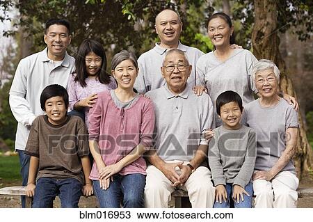 Stock Image - Asian family smiling together outdoors. Fotosearch