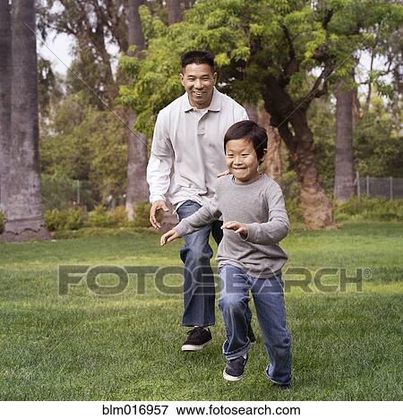 Stock Photo - Asian father and son playing outdoors. Fotosearch