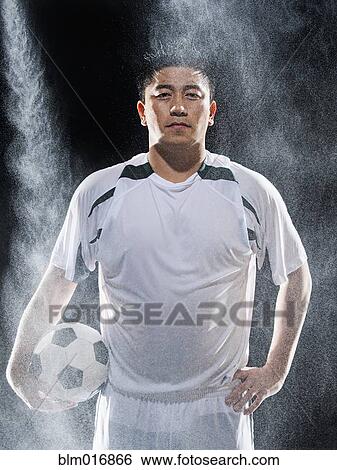 Asian soccer player standing in rain View Large Photo Image Stock Photograph - Asian soccer player standing in rain. Fotosearch