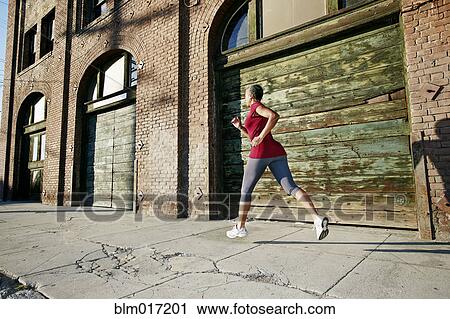 Black woman running on city street View Large Photo Image Stock Image - Black woman running on city street. Fotosearch