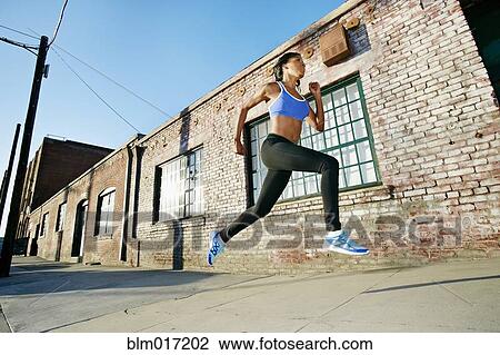 Black woman running on city street View Large Photo Image Stock Image - Black woman running on city street. Fotosearch