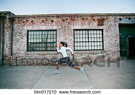 Black woman running on city street View Large Photo Image Stock Image - Black woman running on city street. Fotosearch