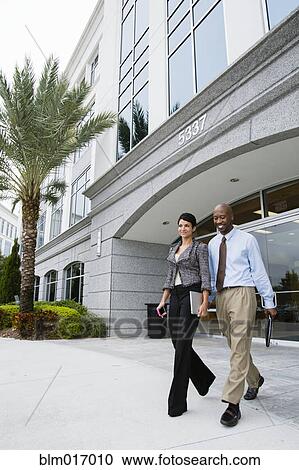 Stock Image - Business people walking together outdoors. Fotosearch