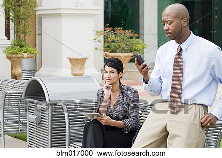 Stock Image - Business people working outdoors. Fotosearch