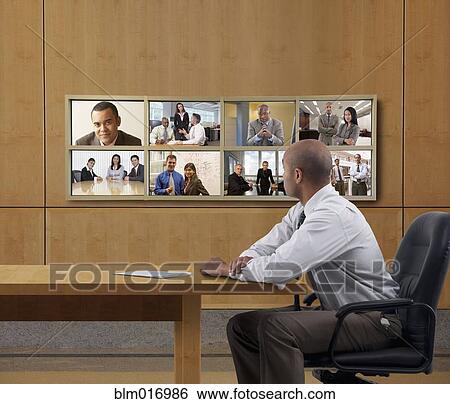 Businessman watching collage screen in office View Large Photo Image Stock Photograph - Businessman watching collage screen in office. Fotosearch
