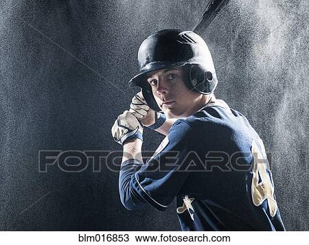 Stock Image - Caucasian baseball player standing in rain. Fotosearch