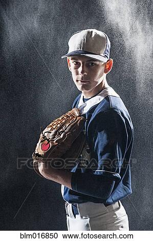 Stock Image - Caucasian baseball player standing under lights. Fotosearch
