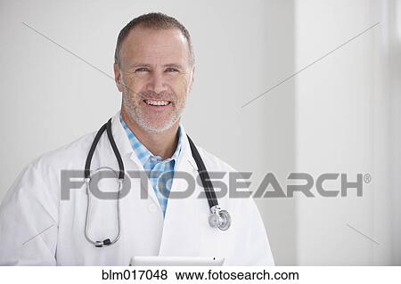 Stock Photo - Caucasian doctor smiling in office. Fotosearch