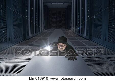 Stock Image - Caucasian man shining light in air vent. Fotosearch