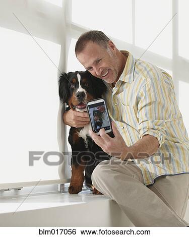 Caucasian man taking picture with dog View Large Photo Image Stock Photograph - Caucasian man taking picture with dog. Fotosearch